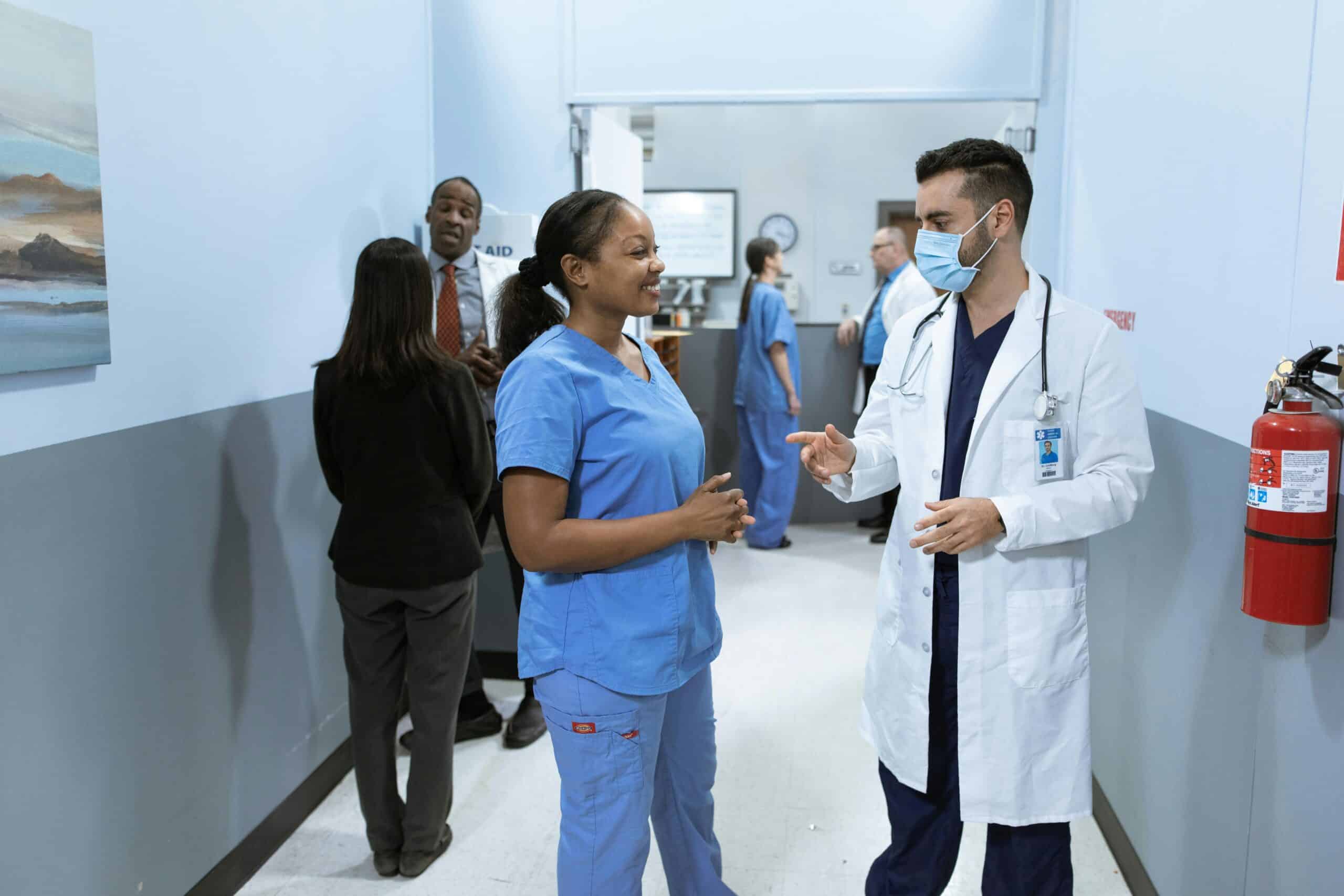 Doctors and nurses in a hospital hallway discussing medical matters.