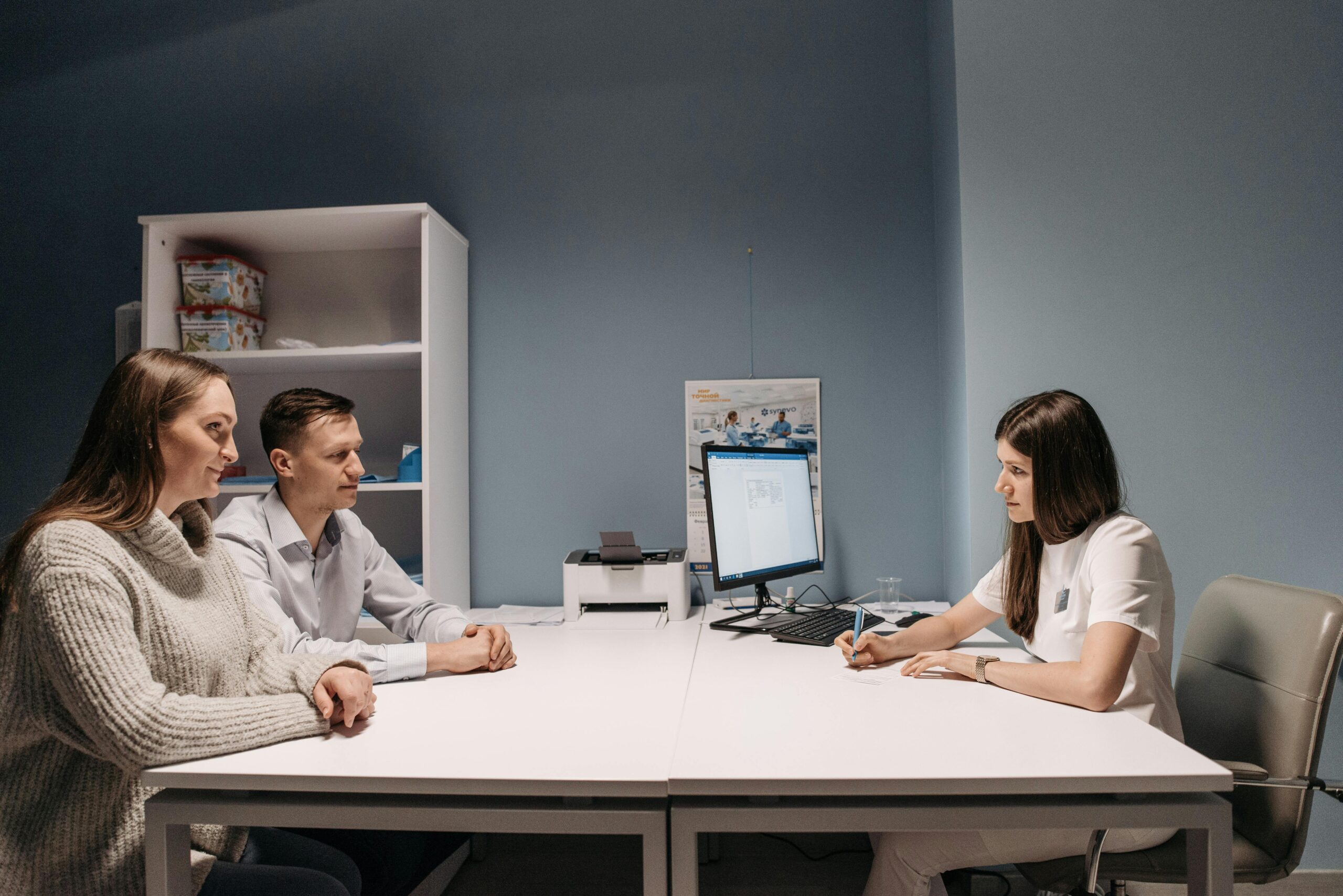 A couple consulting with a doctor in a medical office for a health check-up.